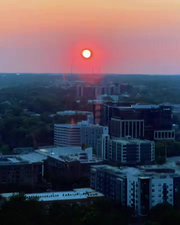 The Raleigh skyline at sunset, sun on the horizon